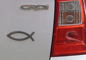 Das Symbol "Fisch" -sichtbar neben dem Rücklicht eines weißen Autos