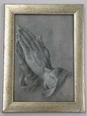 Das Bild im goldenen Bilderrahmen zeigt die betenden Hände von Dürer Das Bild im goldenen Bilderrahmen zeigt die betenden Hände von Dürer.
